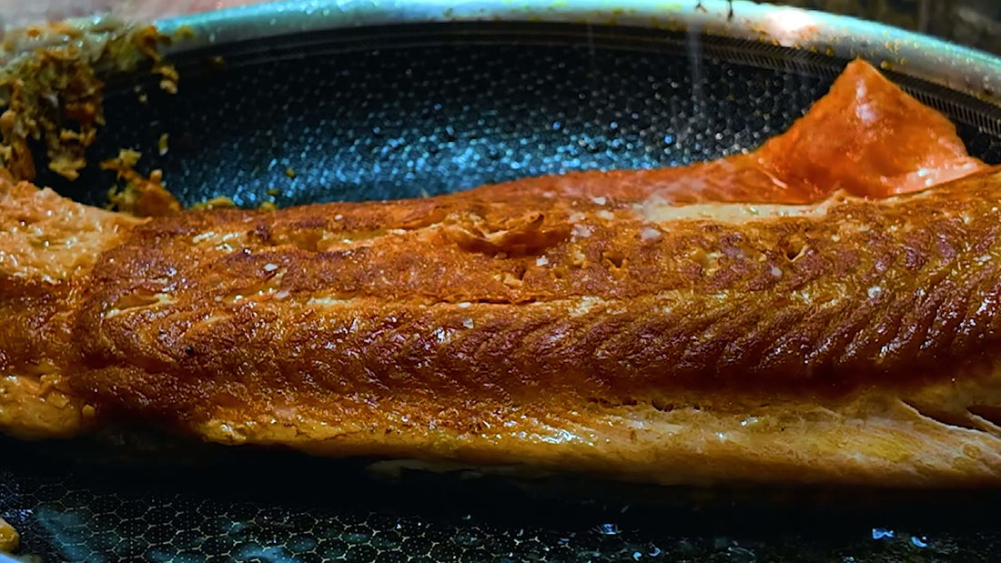 A glazed loaf of meat browning in a dark roasting pan